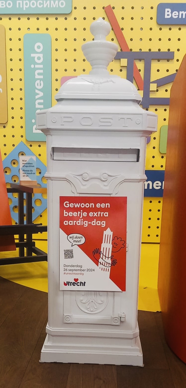 Een brievenbus met de poster Gewoon een beetje extra aardig-doen.