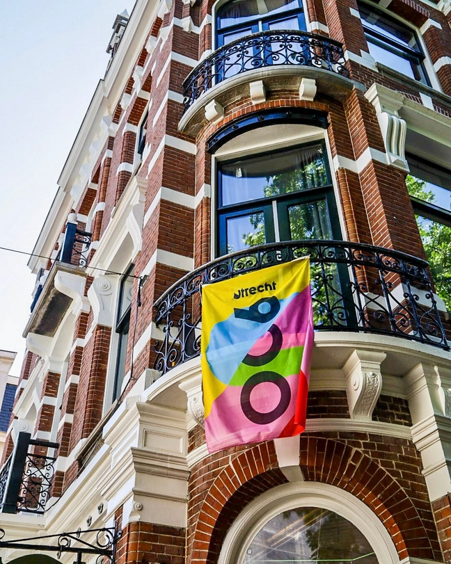 Een vlag met Utrecht 900 jaar die aan een reling hangt.
