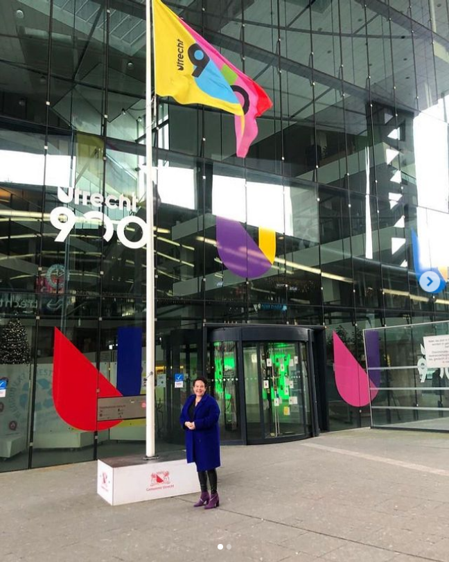 Het gemeentehuis van Utrecht met de burgemeester die onder een vlag staat in de stijl van Utrecht 900 jaar.