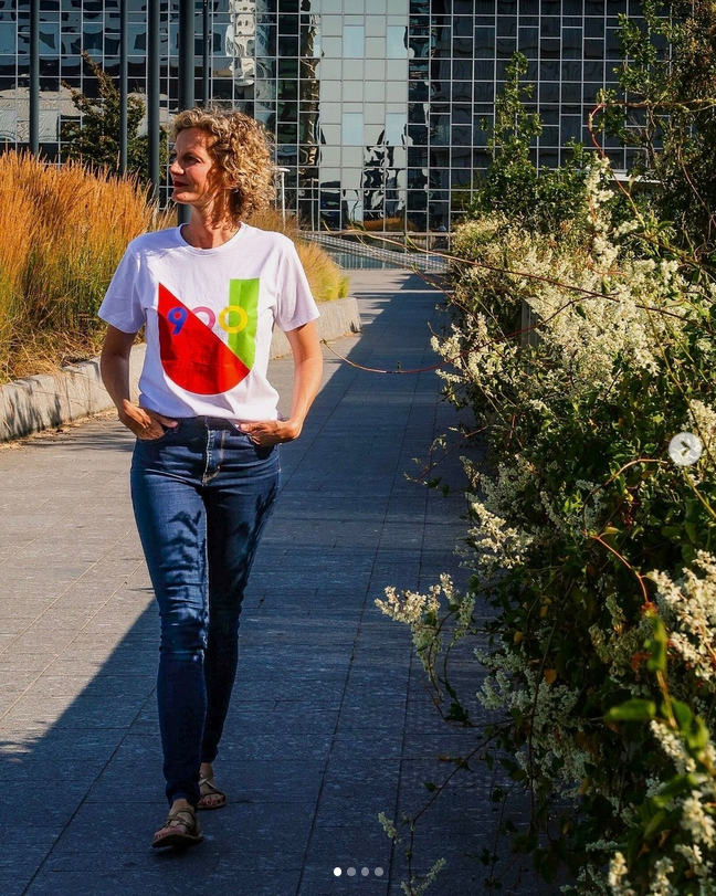 Iemand die bij Utrecht Centraal loopt met een wit shirt aan met het U logo van Utrecht 900 jaar aan.